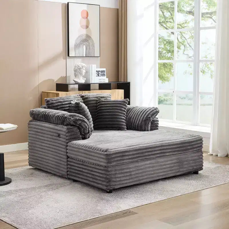 Poltrona chaise longue oversize da interno, comodo divano lounge in velluto a coste con ampi braccioli imbottiti e cuscini decorativi, accogliente divano letto per soggiorno