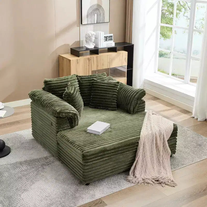 Poltrona chaise longue oversize da interno, comodo divano lounge in velluto a coste con ampi braccioli imbottiti e cuscini decorativi, accogliente divano letto per soggiorno